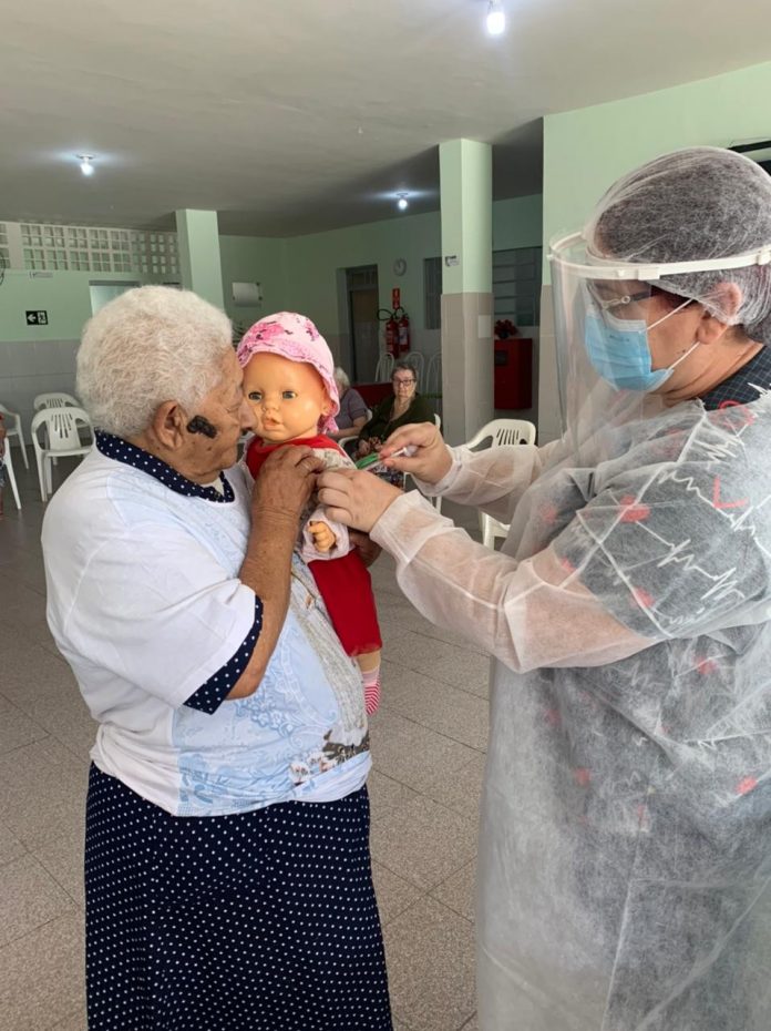 Após ser vacinada contra Covid-19, idosa moradora de abrigo pede que técnica ‘vacine’ boneca, na PB