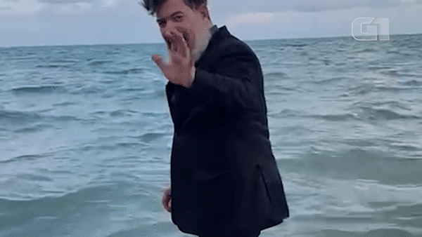 Juiz mergulha no mar de paletó e gravata para comemorar aposentadoria, na PB; VÍDEO