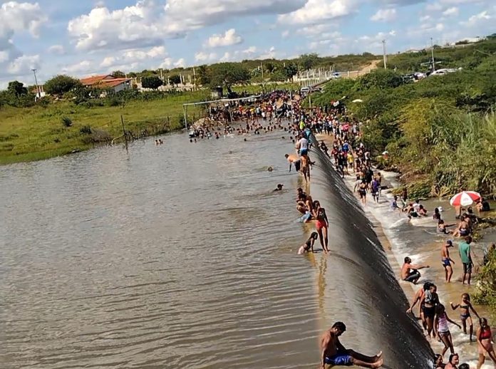 Aglomeração se forma no entorno de açude após reservatório sangrar, em Taperoá, na Paraíba