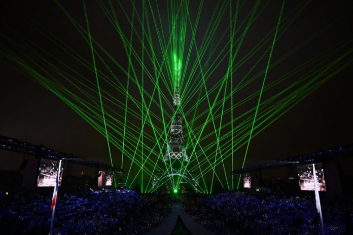 Bandeira dos Jogos Olímpicos é hasteada em frente à Torre Eiffel